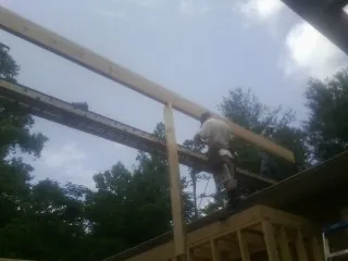 Carpenter setting a ridge beam over a new addition frame — Ice Dam Removal by Roofing Brothers in Lambertville