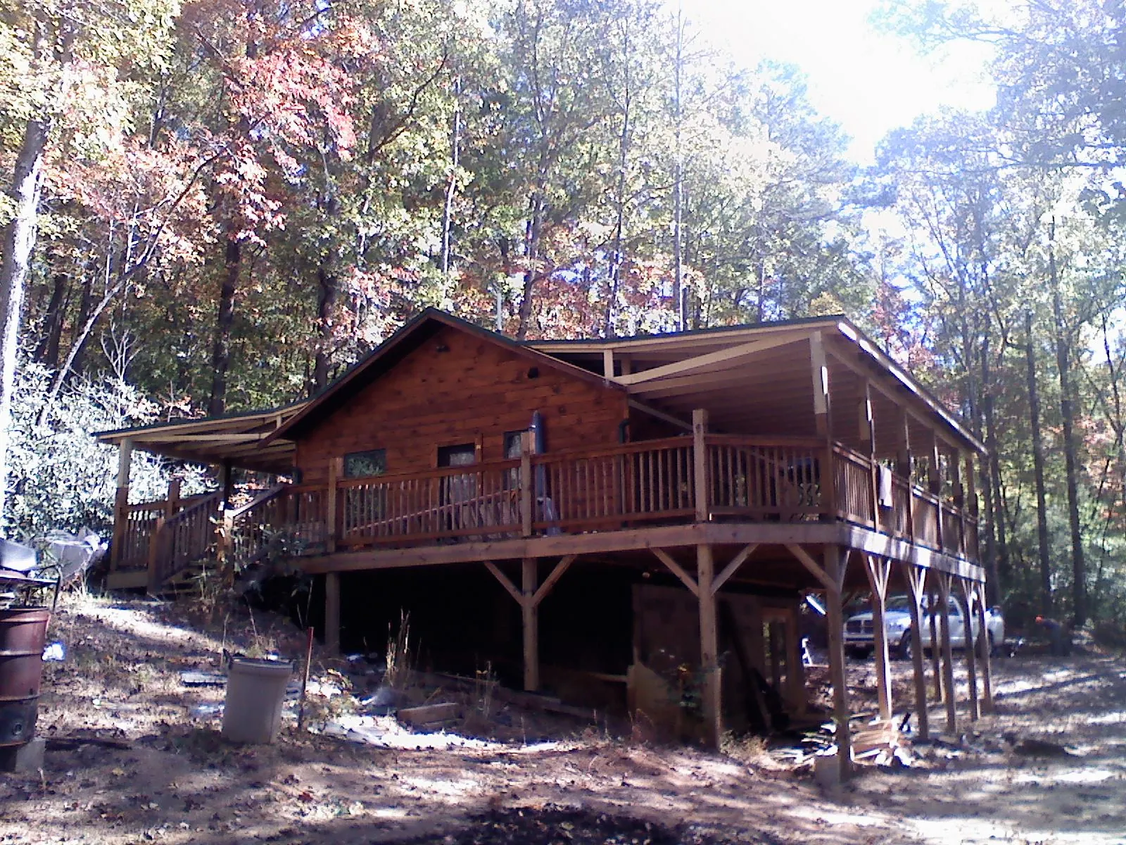 Log cabin with a wraparound porch and metal roof in the fall in Lambertville