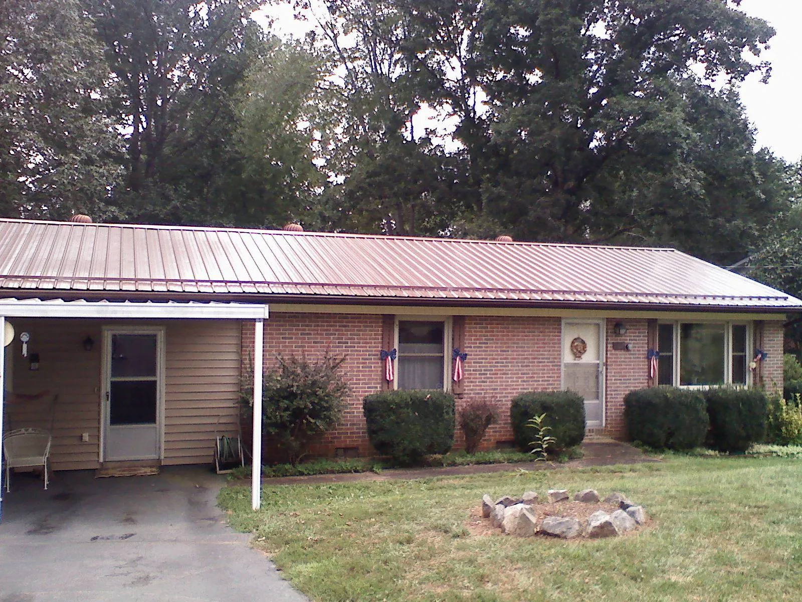 Bronze metal roof and carport on a brick ranch home — Roof Repair work by our crew in Lambertville
